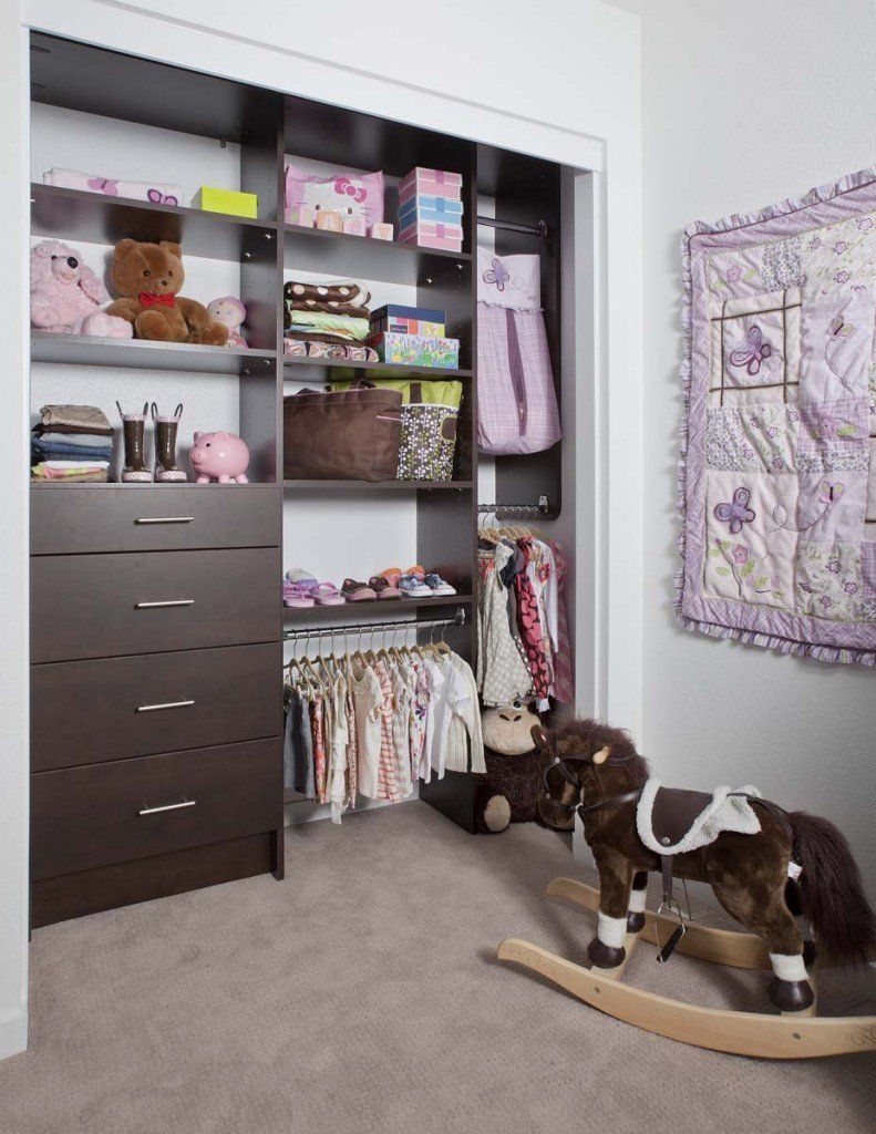 A rocking horse is in a closet filled with clothes and toys