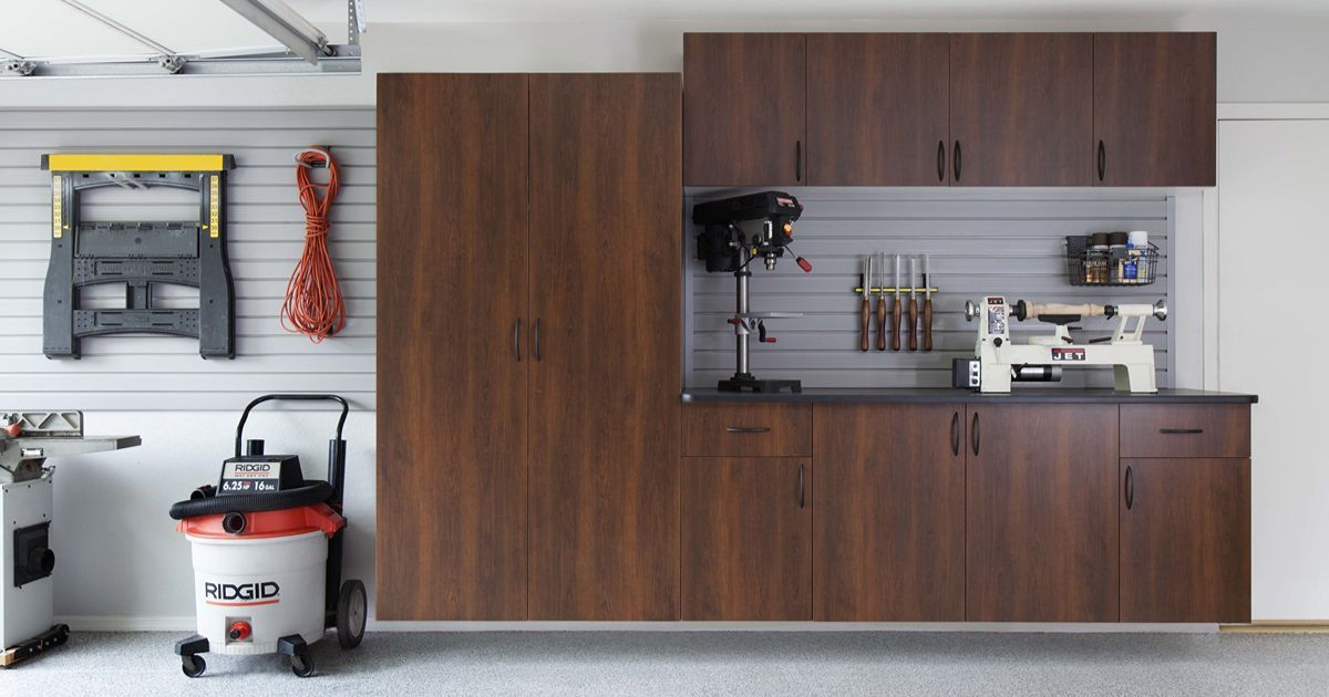 Garage workspace with brown cabinets, tools, and a vacuum cleaner.