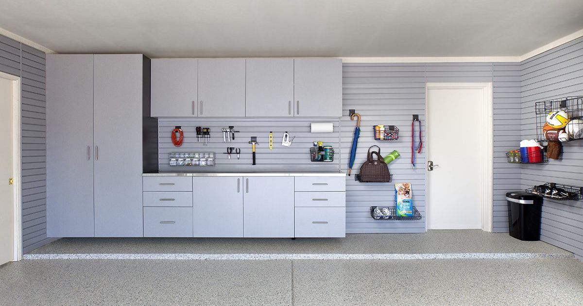 Gray walk-in closet with a desk, glass-front cabinets, hanging clothes, and storage bins; gold accents.