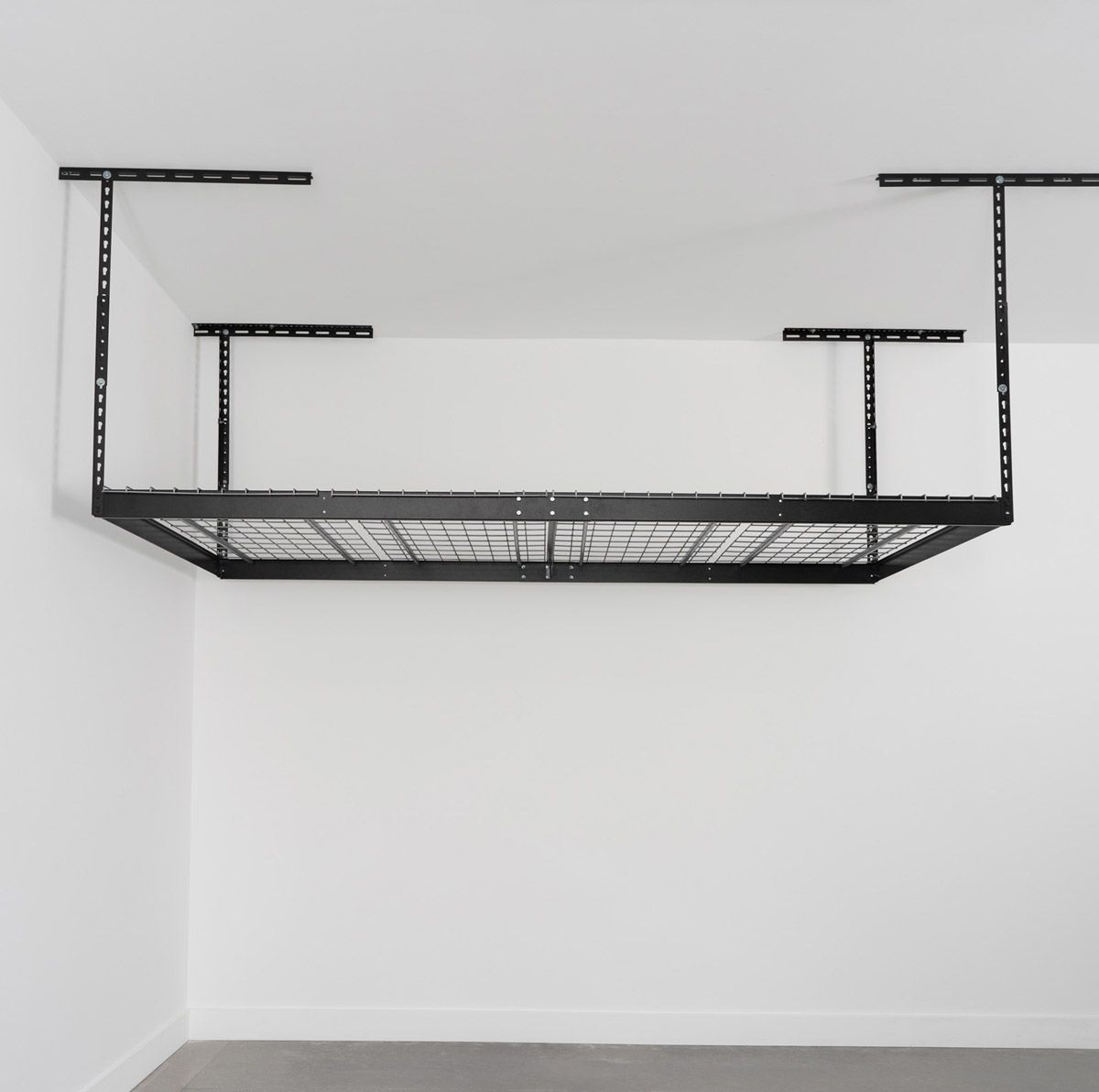 Black metal ceiling-mounted storage rack in a white-walled garage.