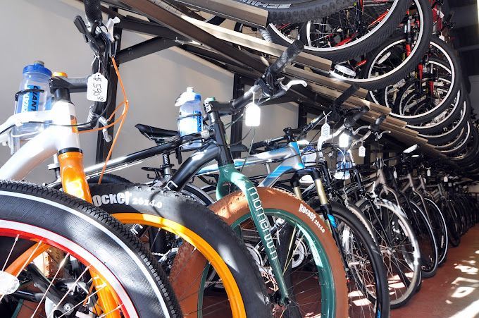 A row of bicycles are lined up in a store.