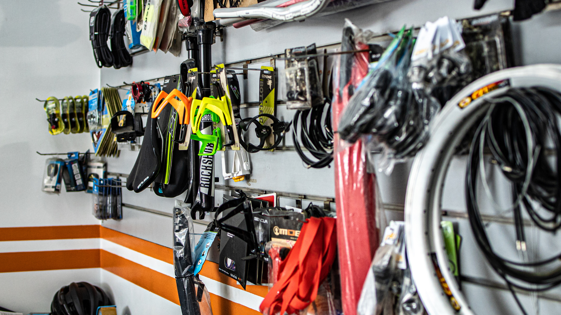 A bicycle shop with a lot of bicycle parts hanging on the wall.
