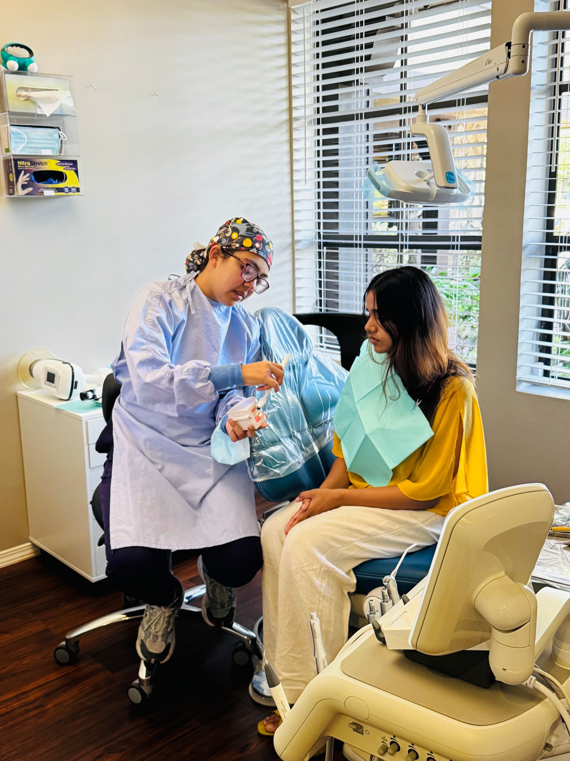 Dentist preparing a patient for treatment in a bright dental exam room