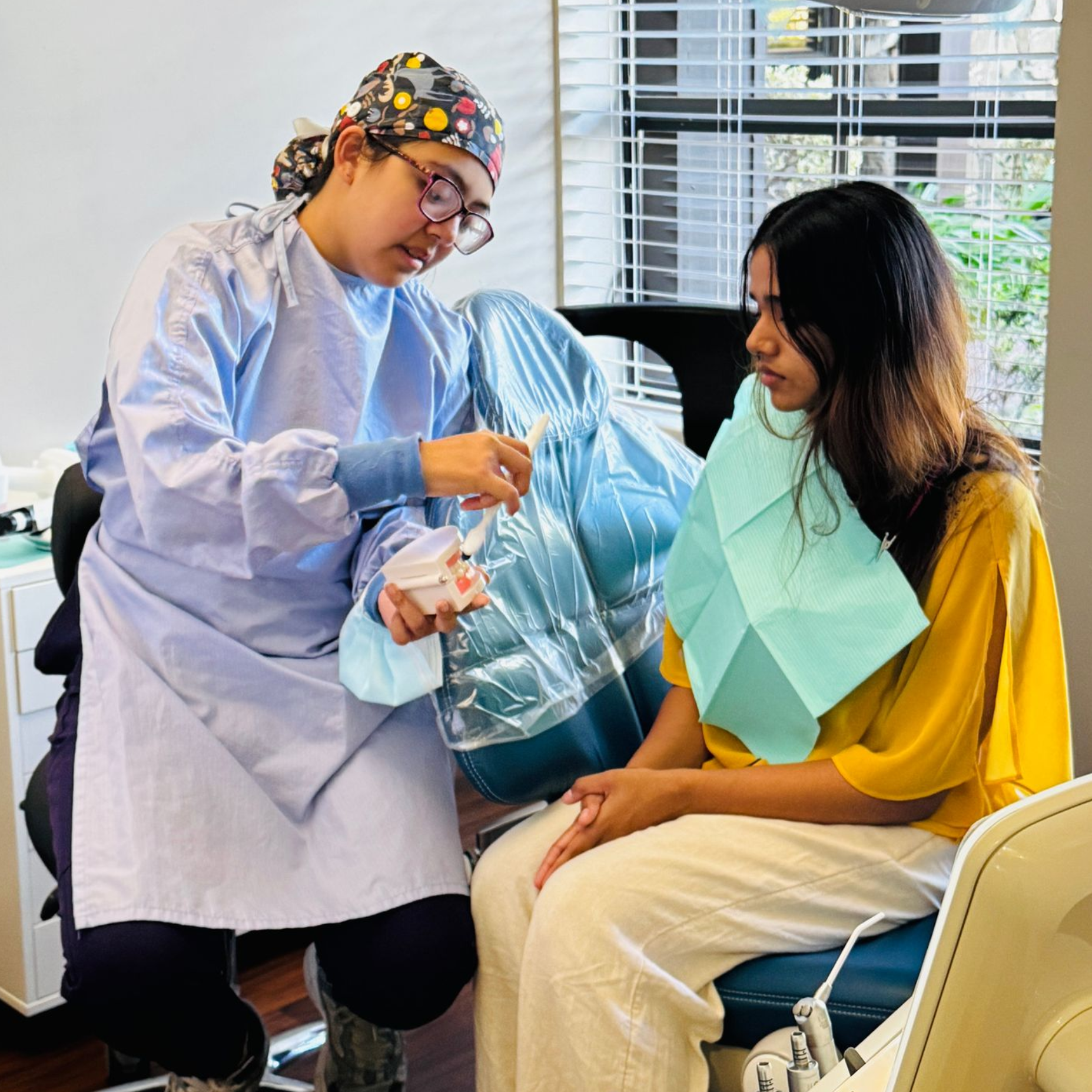 Dentist examining a young woman's teeth with tools in a dental office.