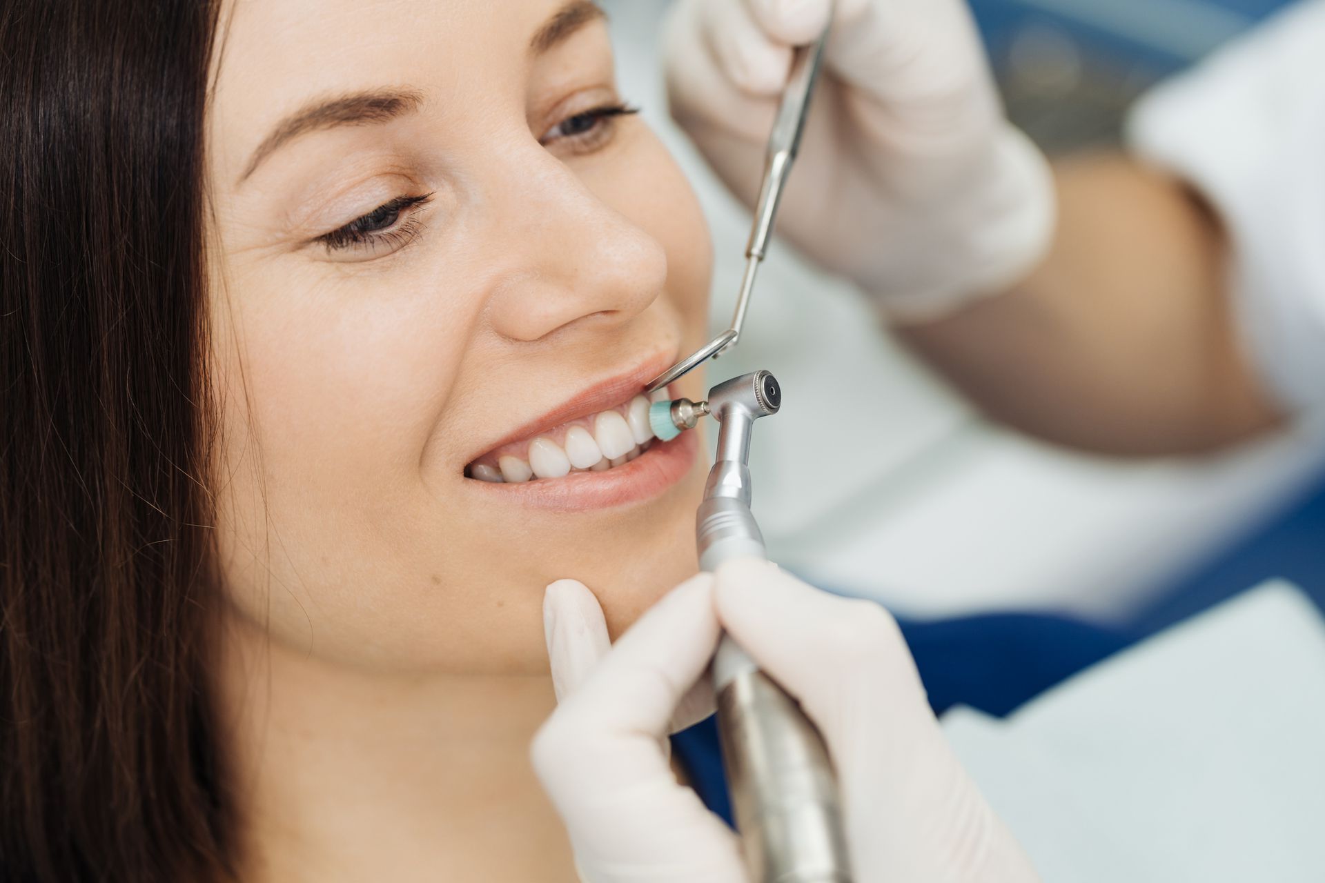 A woman is getting her teeth examined by a dentist.