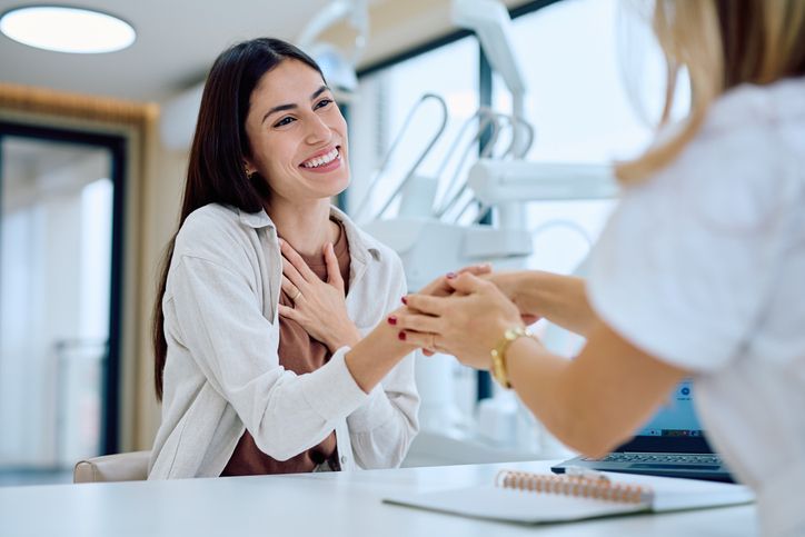 Smiling patient speaking with a doctor in a bright clinic reception area