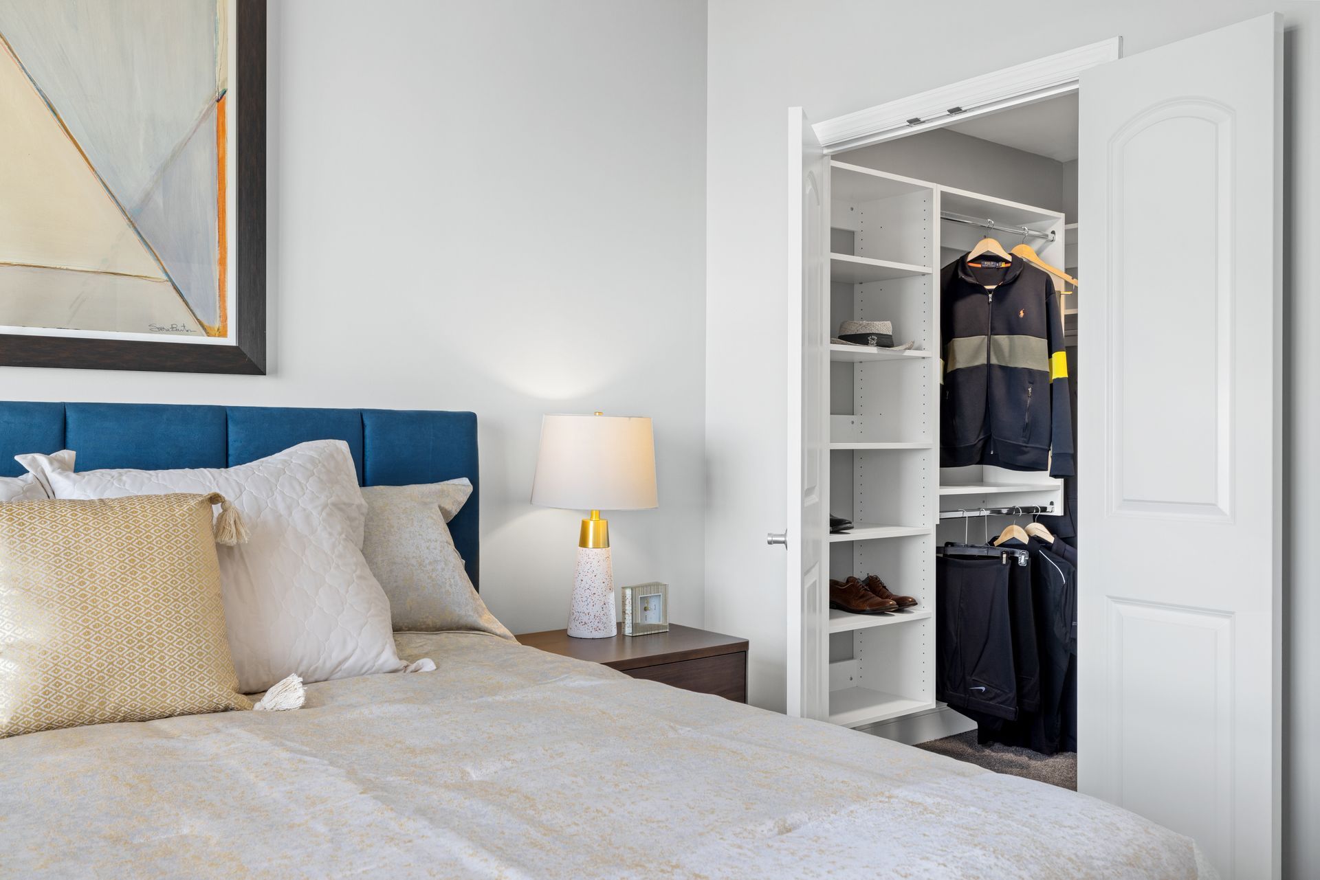 A bedroom with a large bed and a walk in closet.