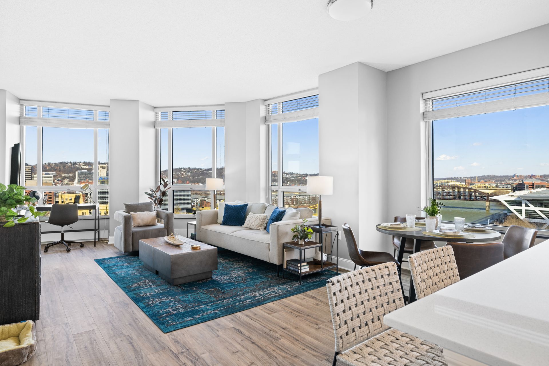 A living room with a couch , chairs , a table and a rug.
