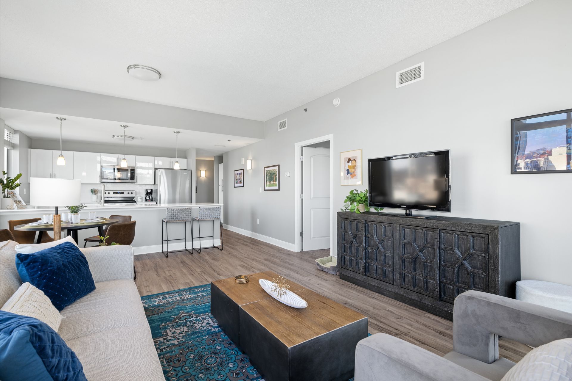 A living room with a couch , chair , coffee table and television.