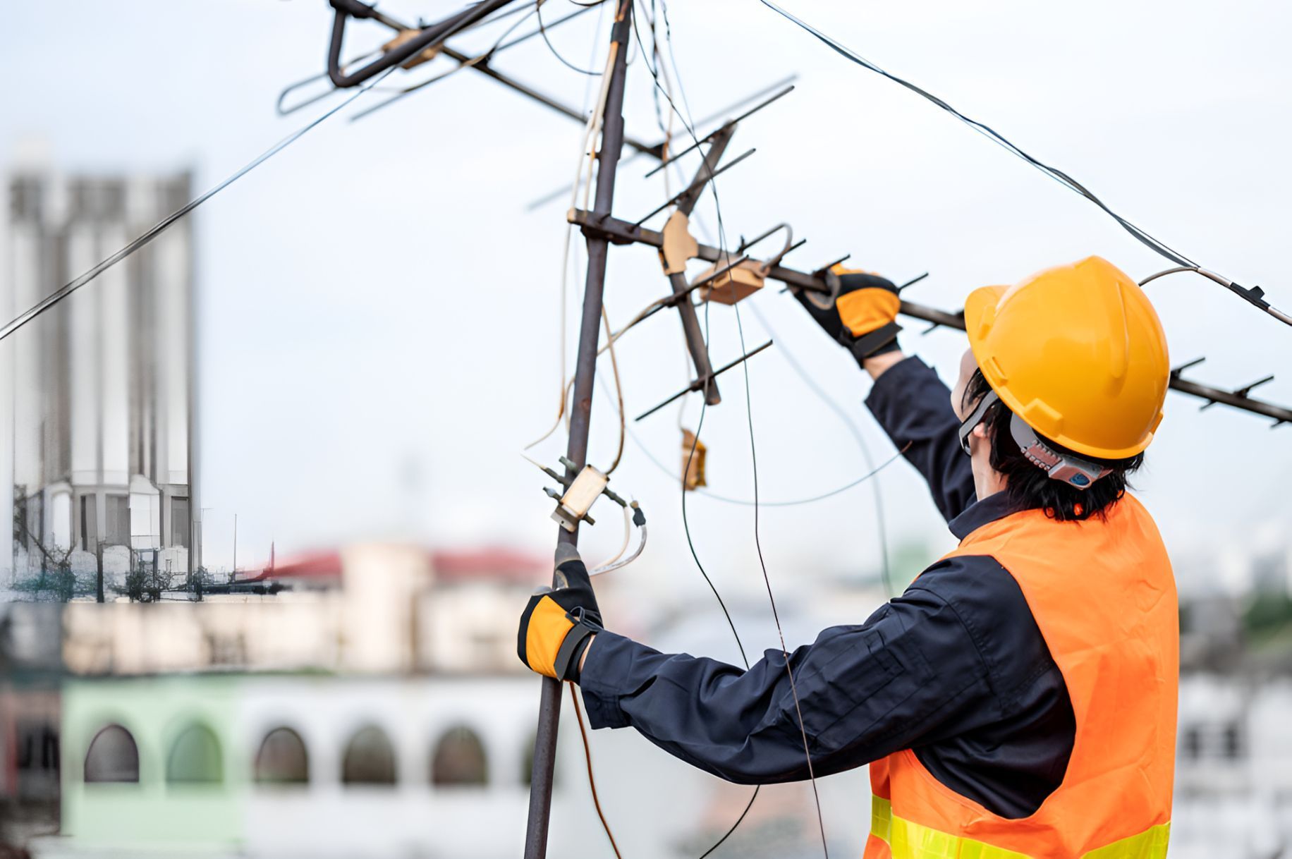 A Man Is Working On A Power Line On Top Of A Building — Entire Power Solutions In Rutherford, NSW