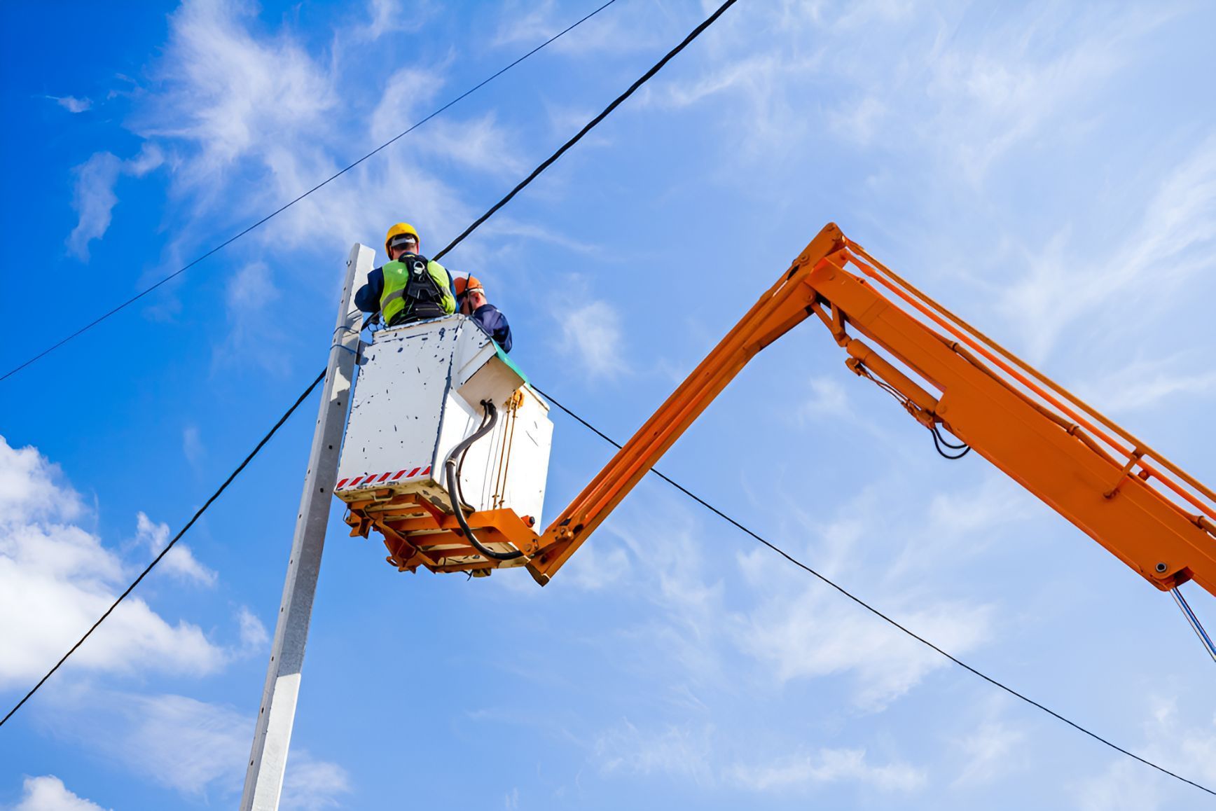 A Man In A Bucket Is Working On A Power Line — Entire Power Solutions In Lambton, NSW