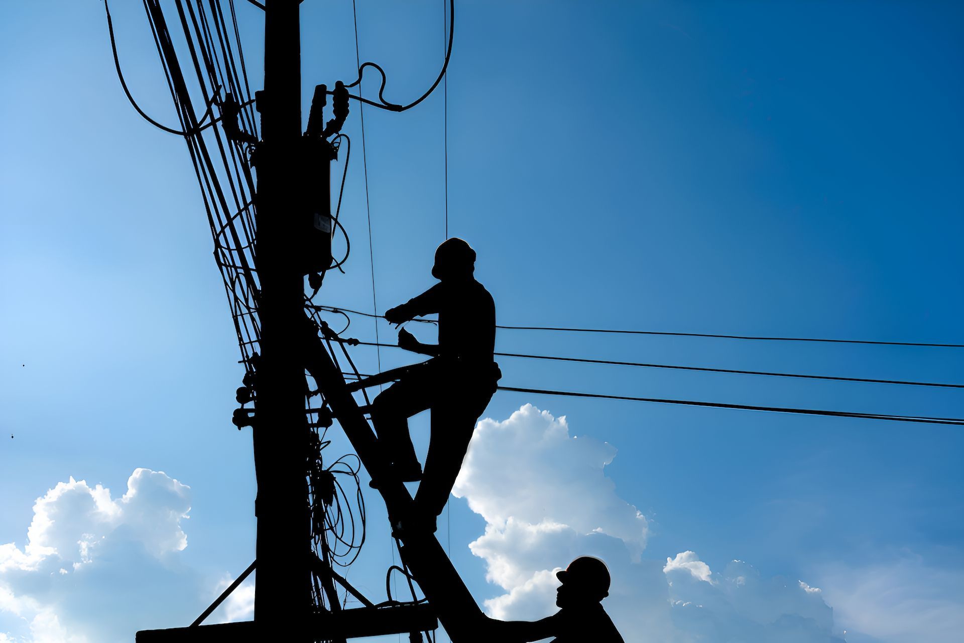 Two Men Are Working On A Powerline With Blue Sky — Entire Power Solutions In Rutherford, NSW