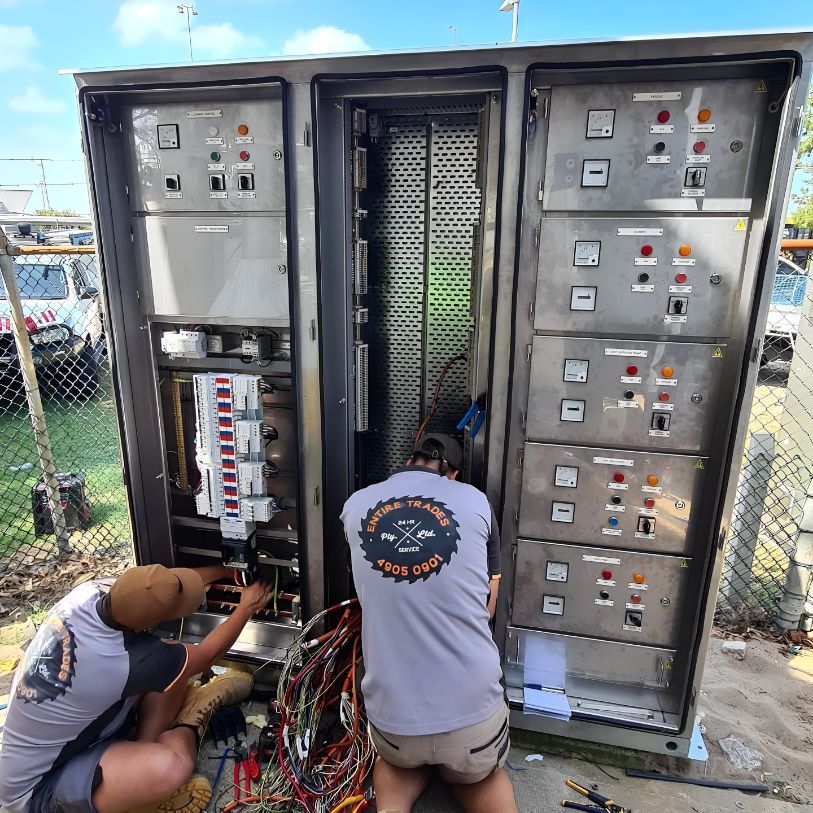 Two Men Are Working On A Large Electrical Box — Entire Power Solutions In Cessnock, NSW