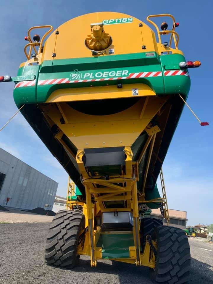Un trattore ploeger giallo e verde è parcheggiato in un parcheggio