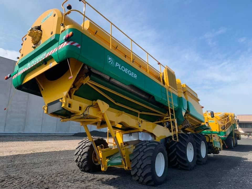 Un trattore giallo e verde con la scritta ploguera sul lato