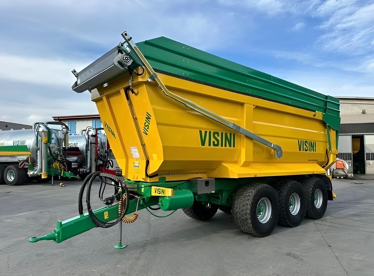 Un camion con cassone ribaltabile giallo e verde è parcheggiato in un parcheggio.