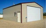 A garage with a white garage door is sitting on top of a dirt field.