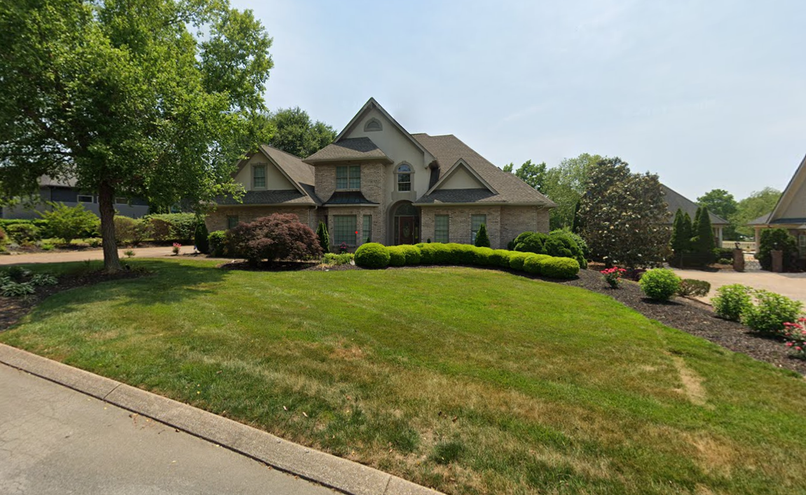 A large house with a lush green lawn in front of it.