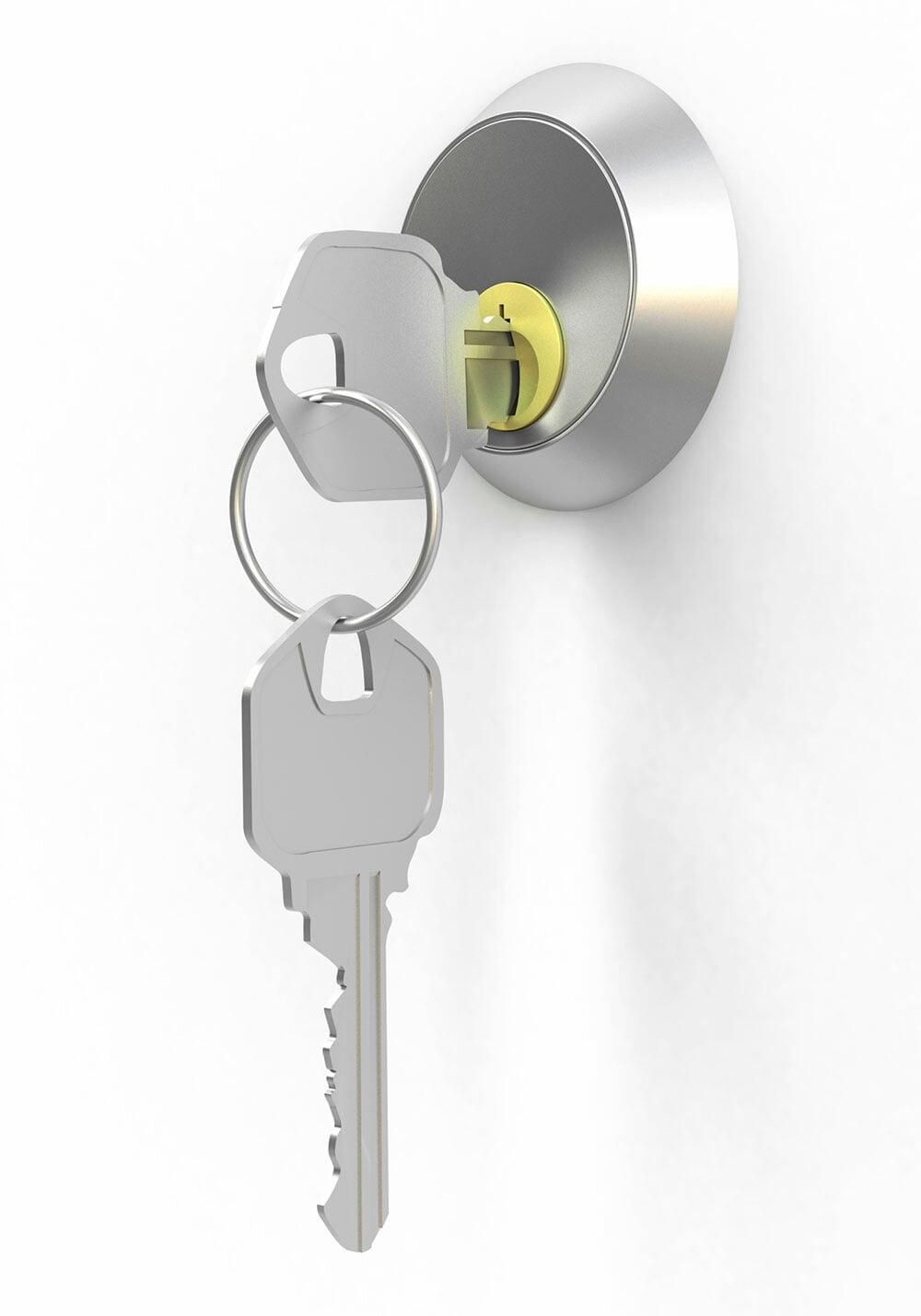 Llaves en una cerradura de puerta plateada, una de ellas parcialmente insertada, sobre un fondo blanco.