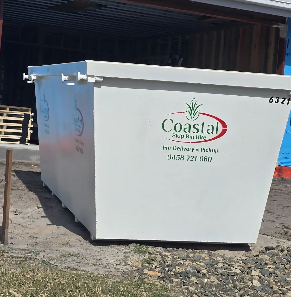 White Coastal container being placed. Outdoors, blue insulation visible. — Coastal Skip Bin Hire In Eli Waters, QLD