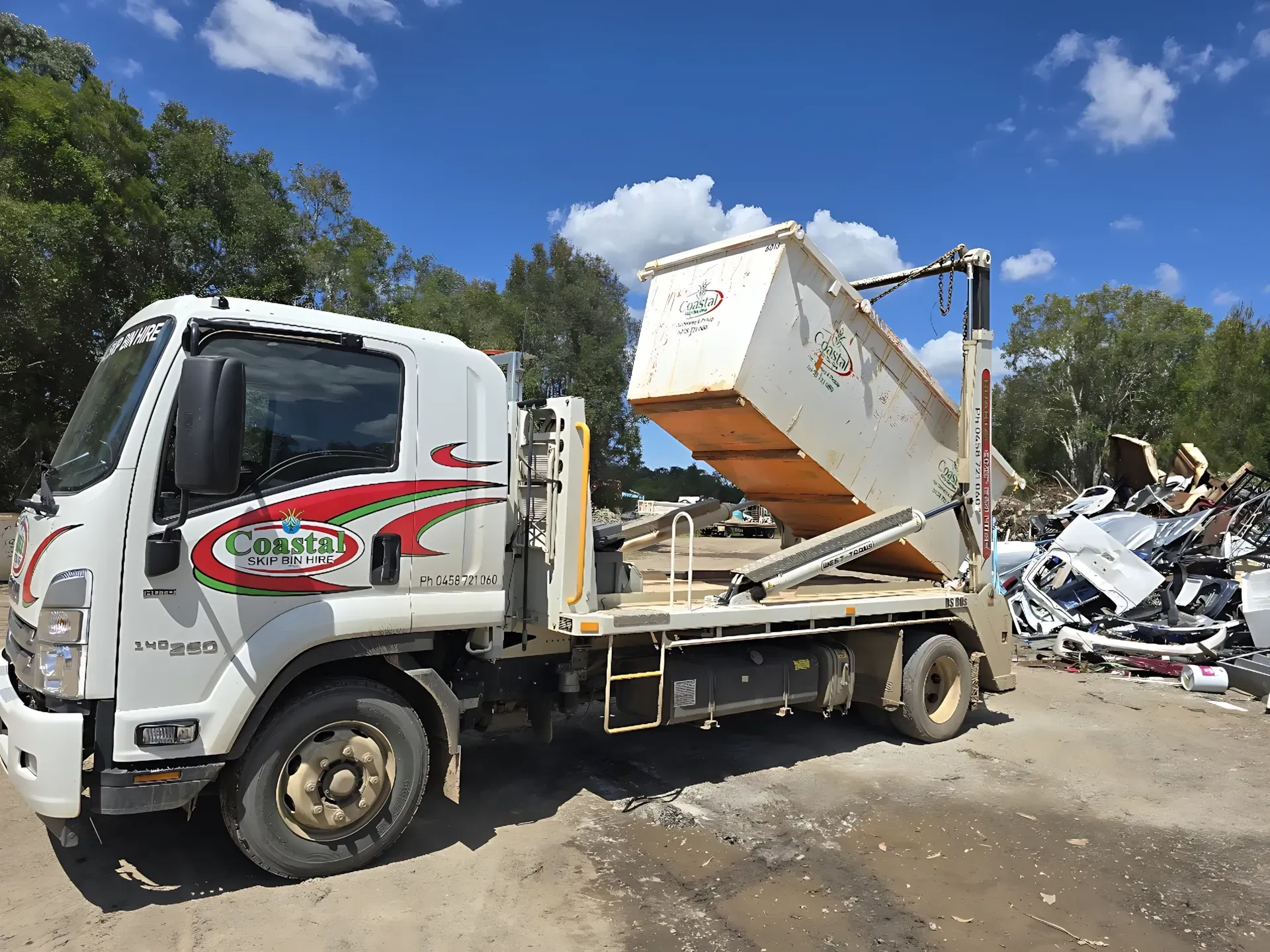 White truck with a liftable dumpster at a recycling yard. — Coastal Skip Bin Hire In Maryborough, QLD