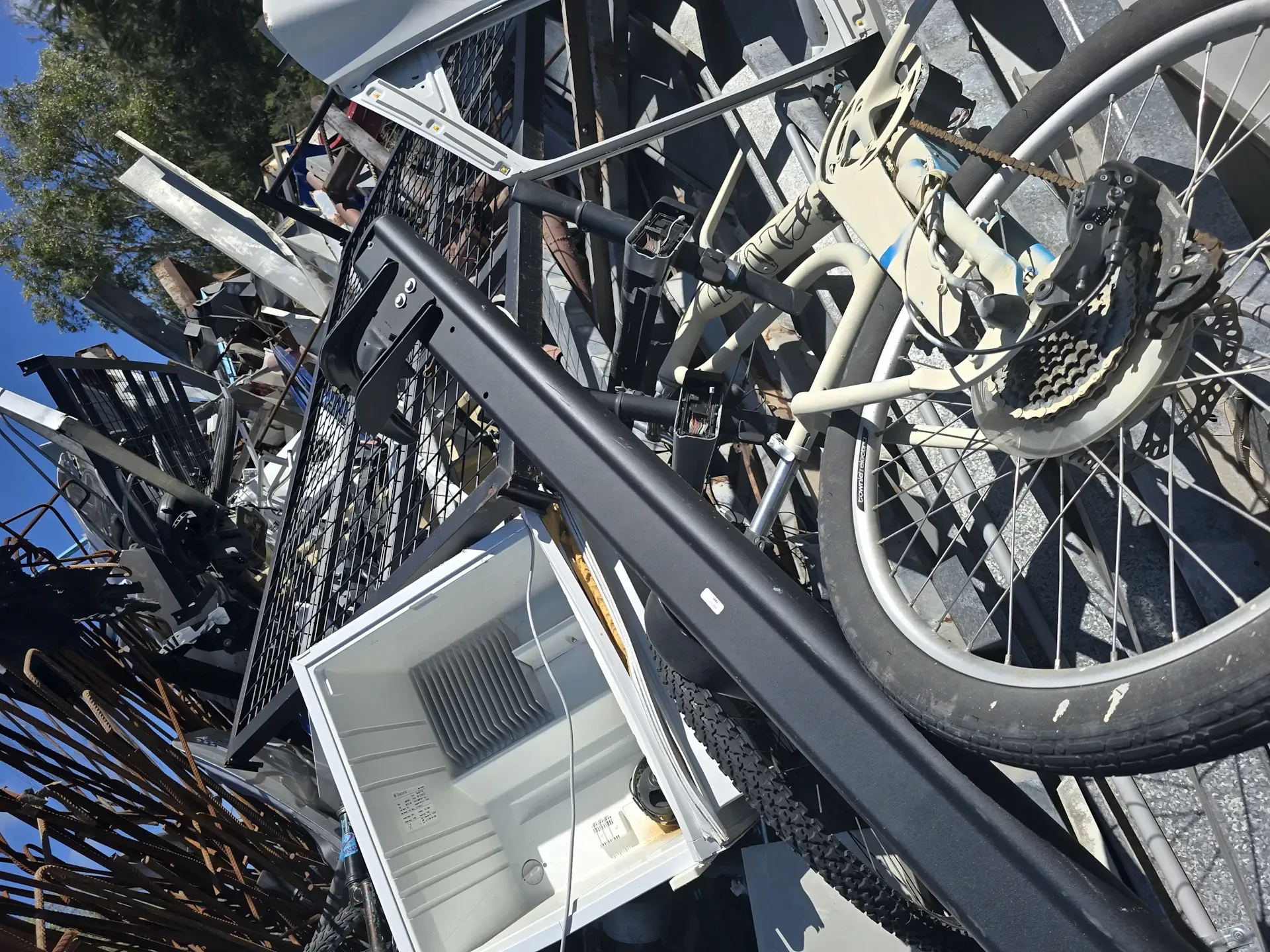Pile of scrap metal including a bicycle, black frame, and white appliance. — Coastal Skip Bin Hire In Craignish, QLD