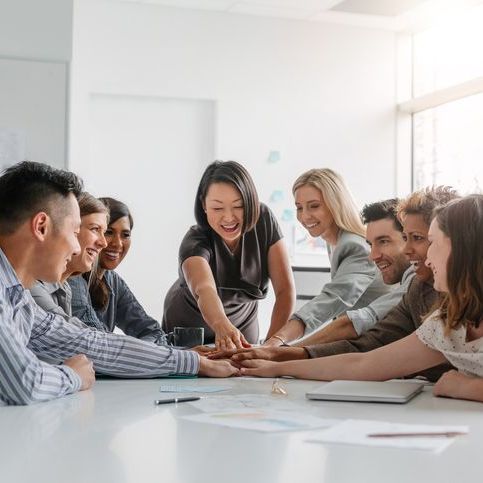 A group of people are sitting around a table having a meeting.