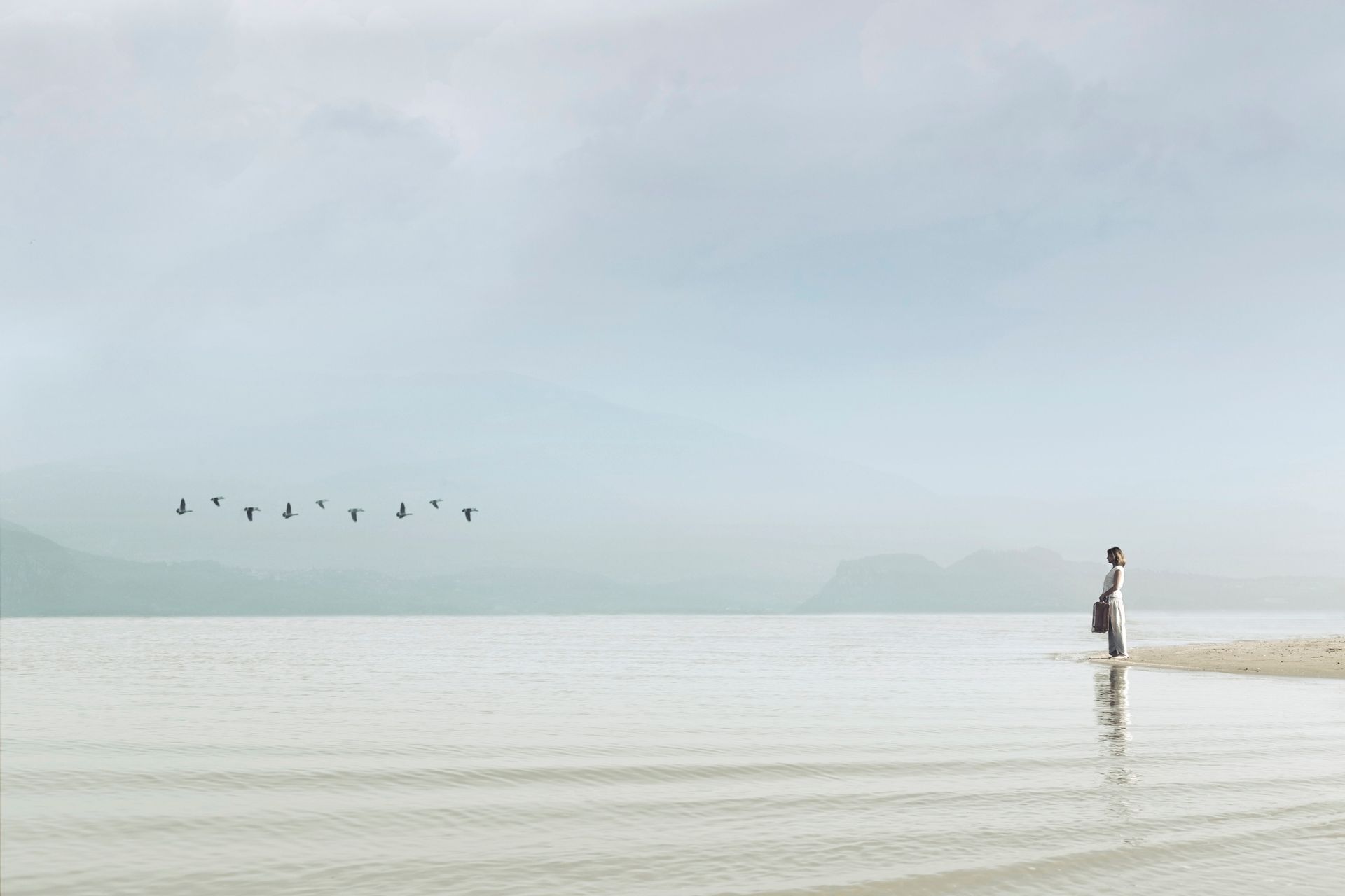 A person is standing in the middle of a body of water.