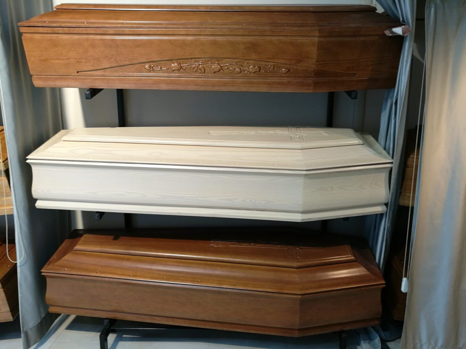 Tre bare di diverse tonalità di legno esposte sugli scaffali.