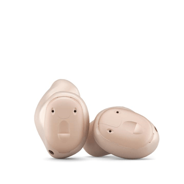 Two beige, in-the-ear hearing aids on a white background.