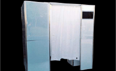 Photo booth with white curtain, a monitor, and silver frame.