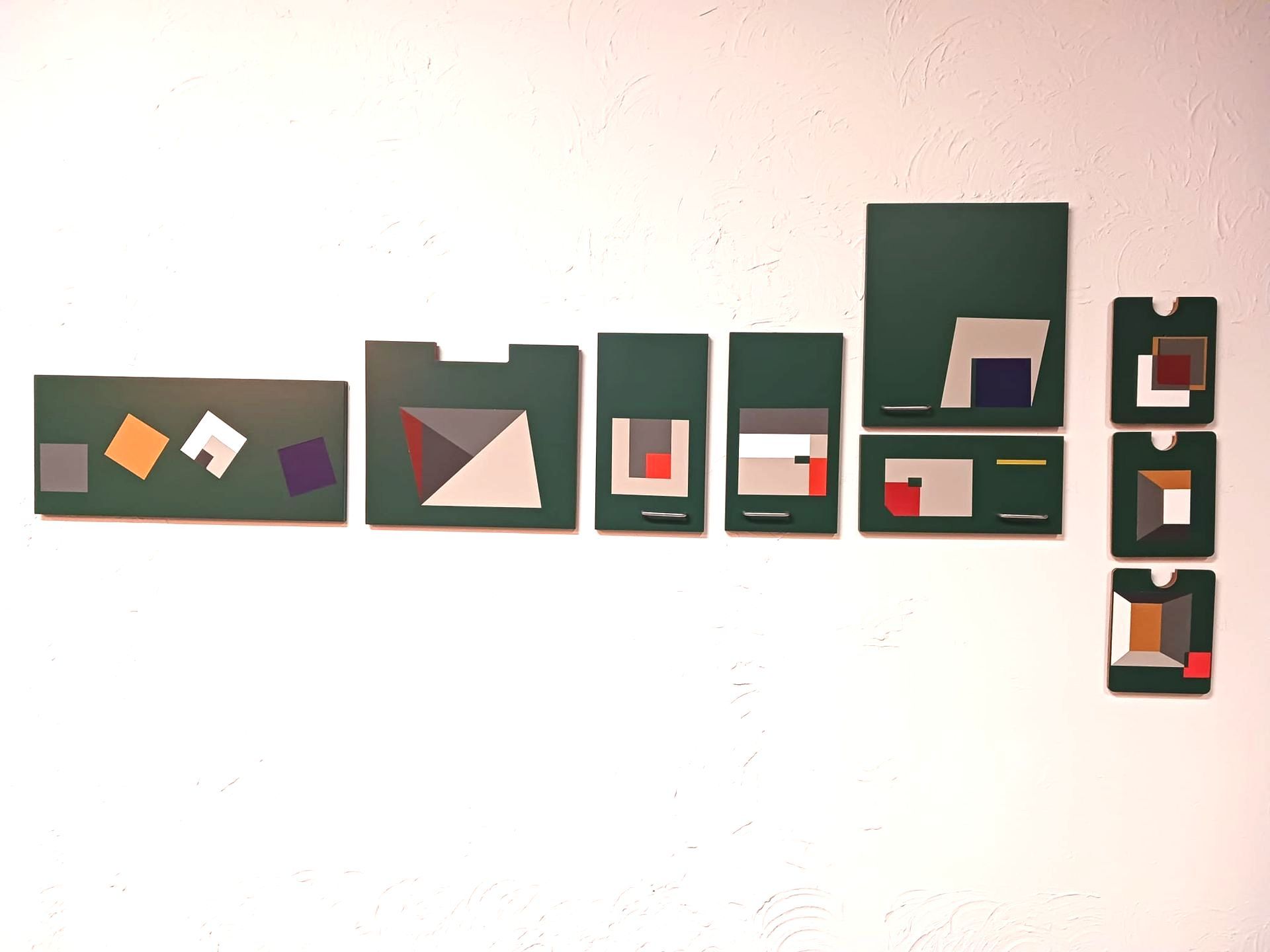 A white wall with a bunch of green squares on it