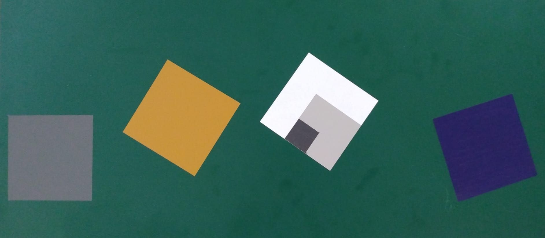 Four squares of different colors are on a green background