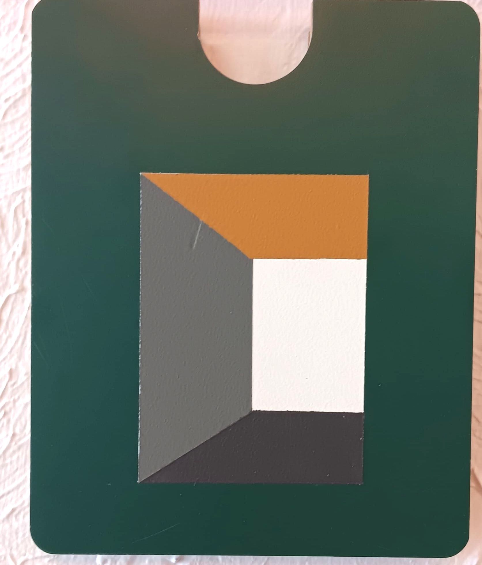 A green door hanger with a geometric design on it