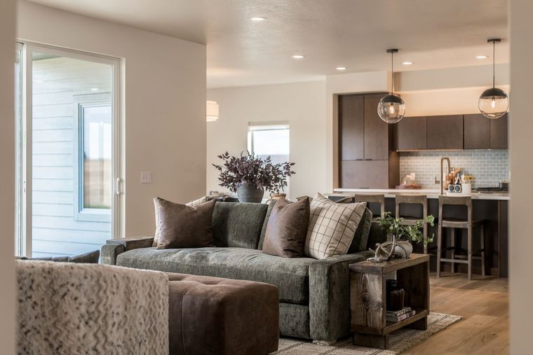 Modern kitchen with wood cabinets, granite island, stainless appliances, and a dining table by a window.