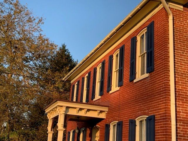 A red brick house with blue shutters on the windows