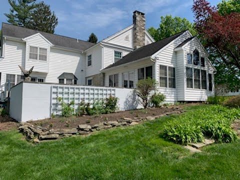 A large white house with a large lawn in front of it.