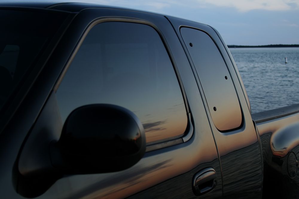 A Black Truck is Parked in Front of a Body of Water — Isa Auto Glass & Upholstery In Menzies, QLD