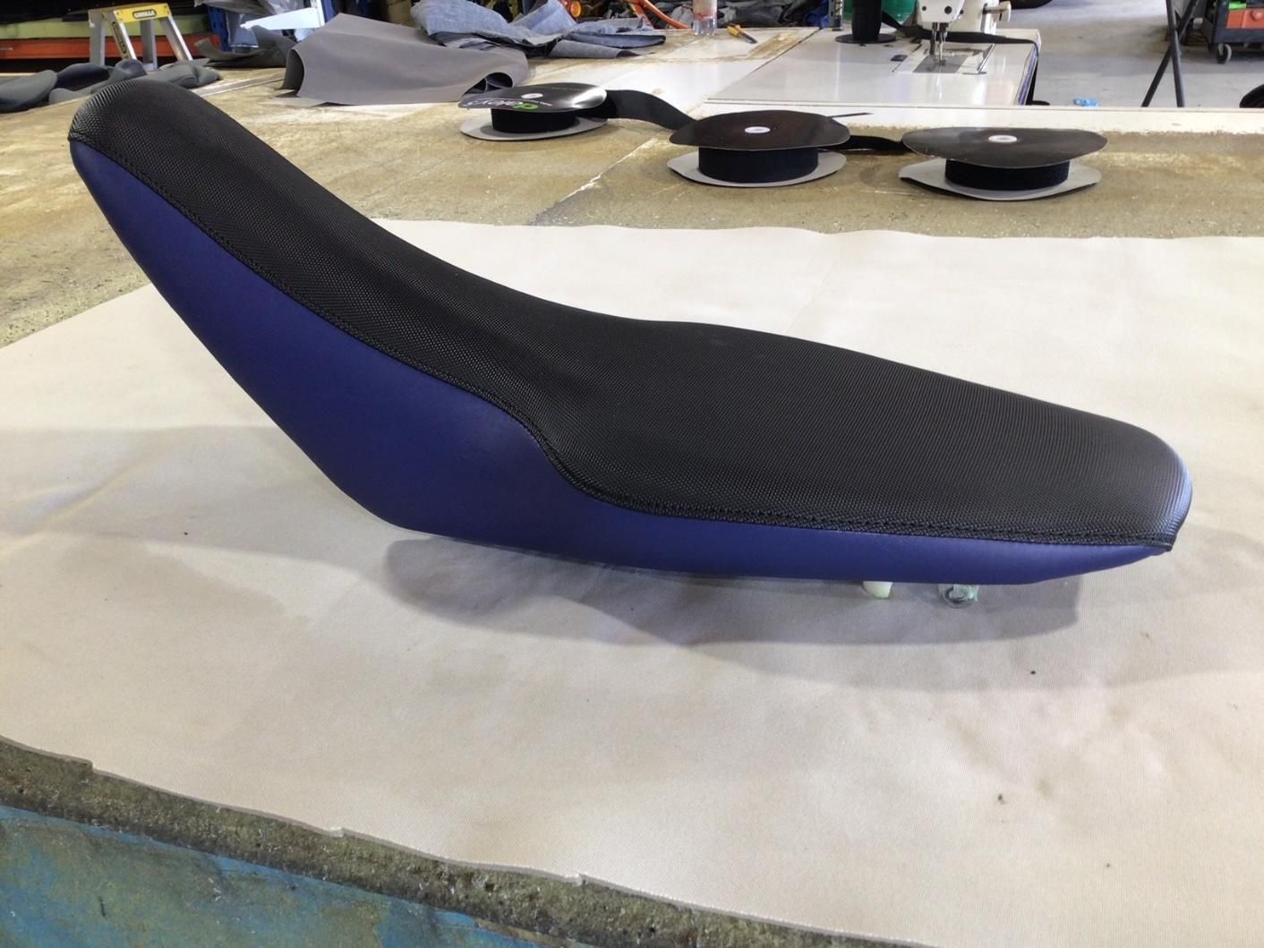 A Blue and Black Motorcycle Seat is Sitting on a Table — Isa Auto Glass & Upholstery In Menzies, QLD