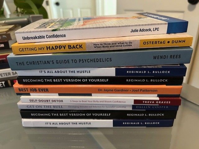 Stack of colorful self-help and spirituality books on a table