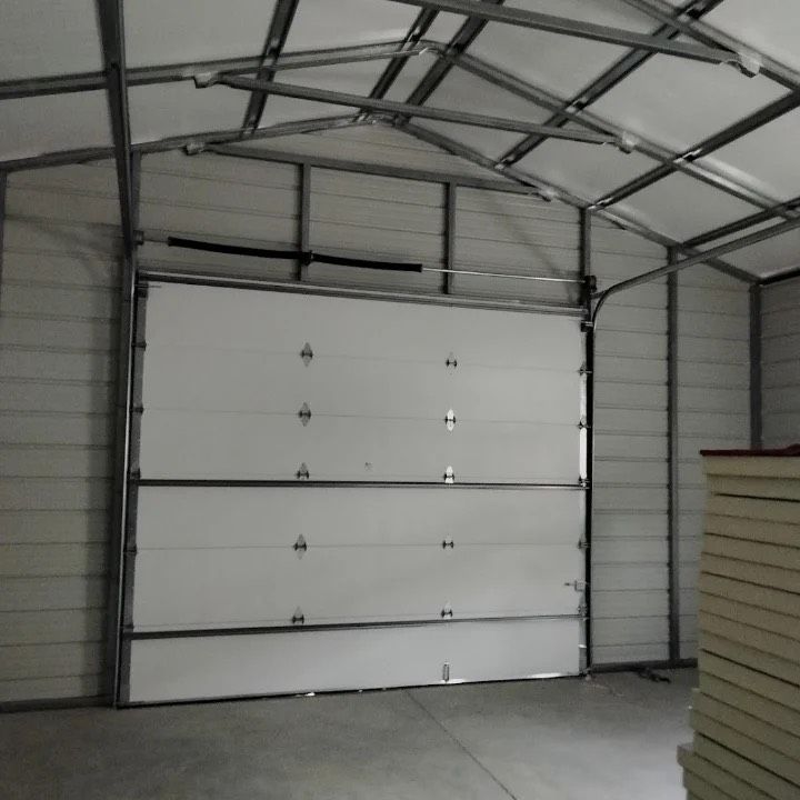 An empty warehouse with a roller shutter door and a concrete floor.