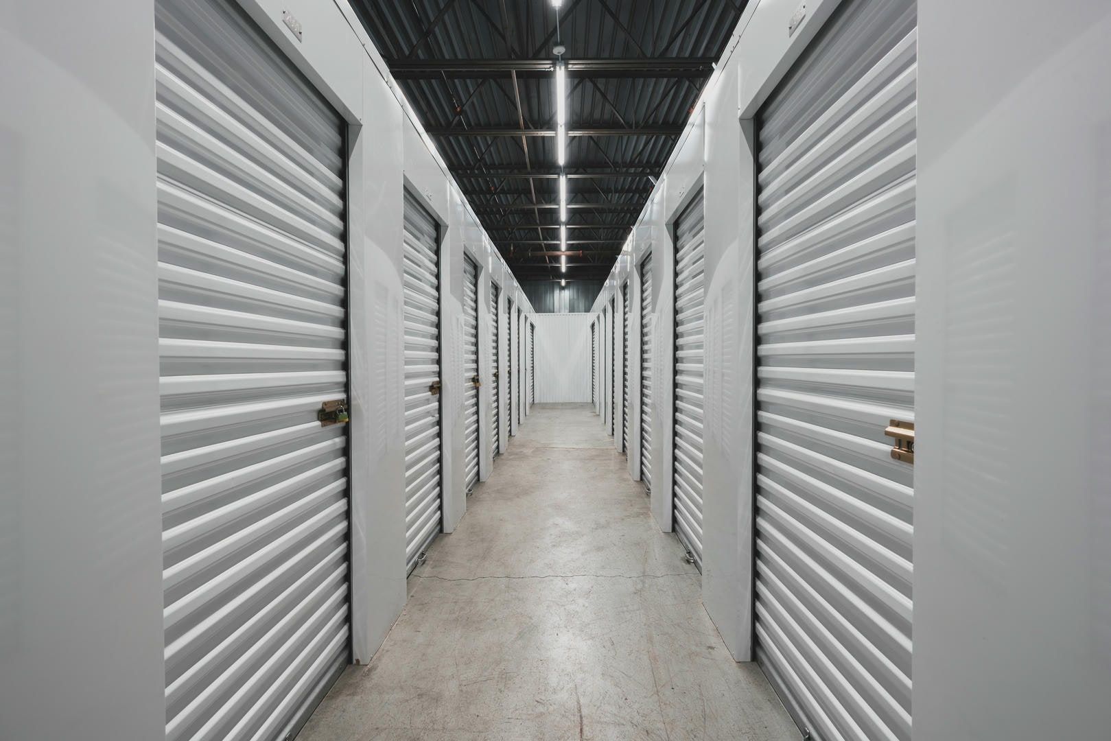 A long hallway filled with rows of empty storage units.