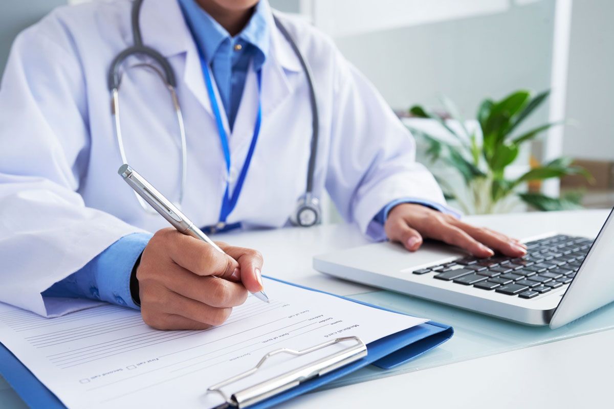 Médico assinando atestado médico para passageiro solicitar reembolso de passagem aérea.