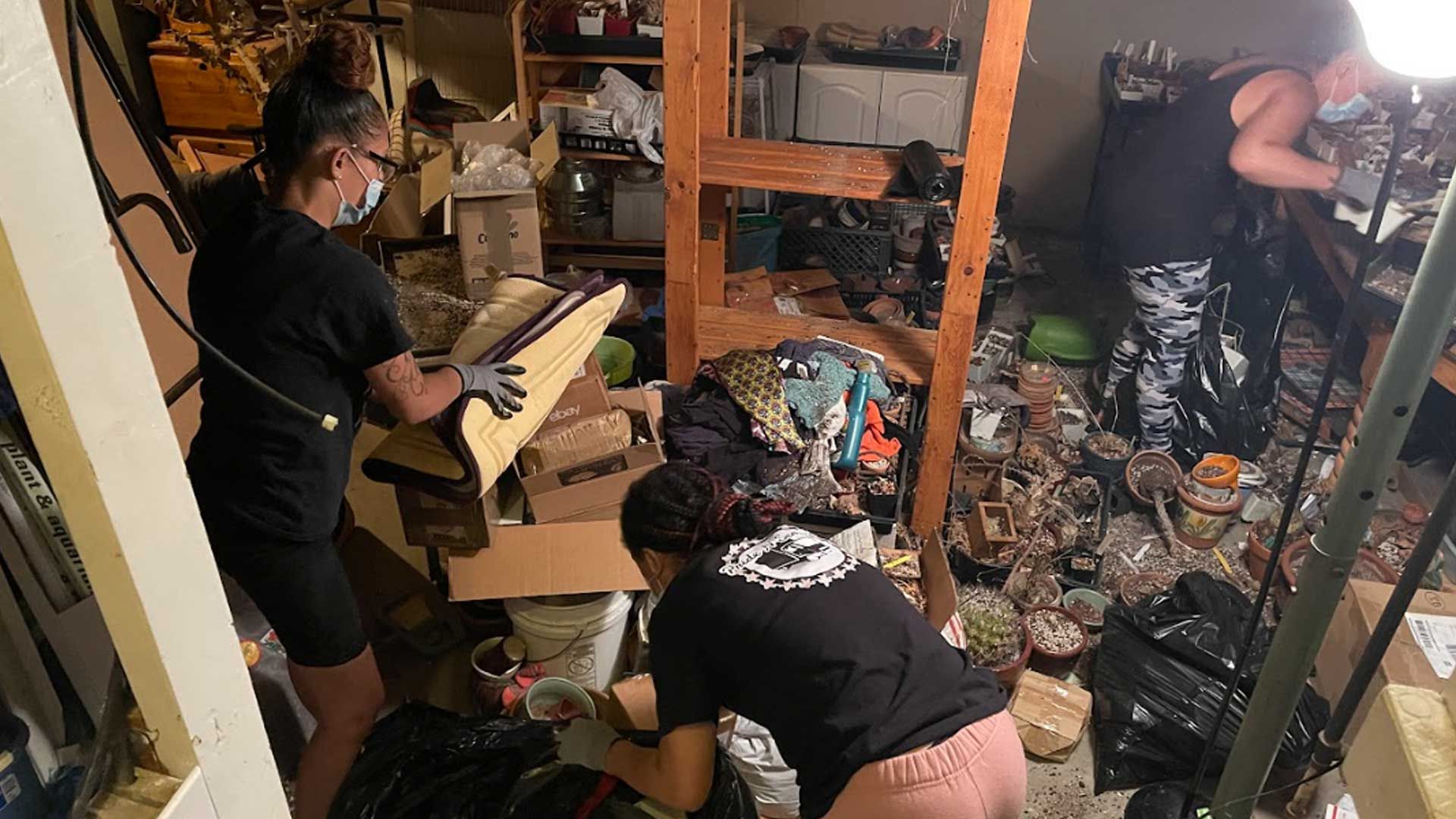 A group of people are working in a messy room.