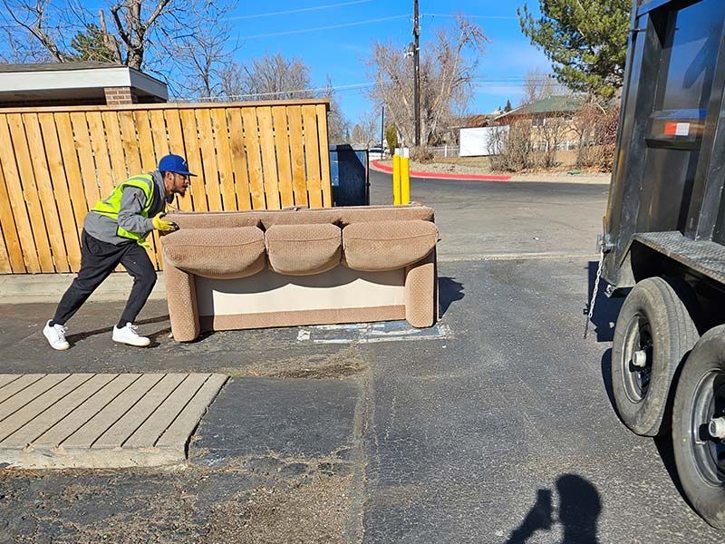 a couch in front of a dumpster
