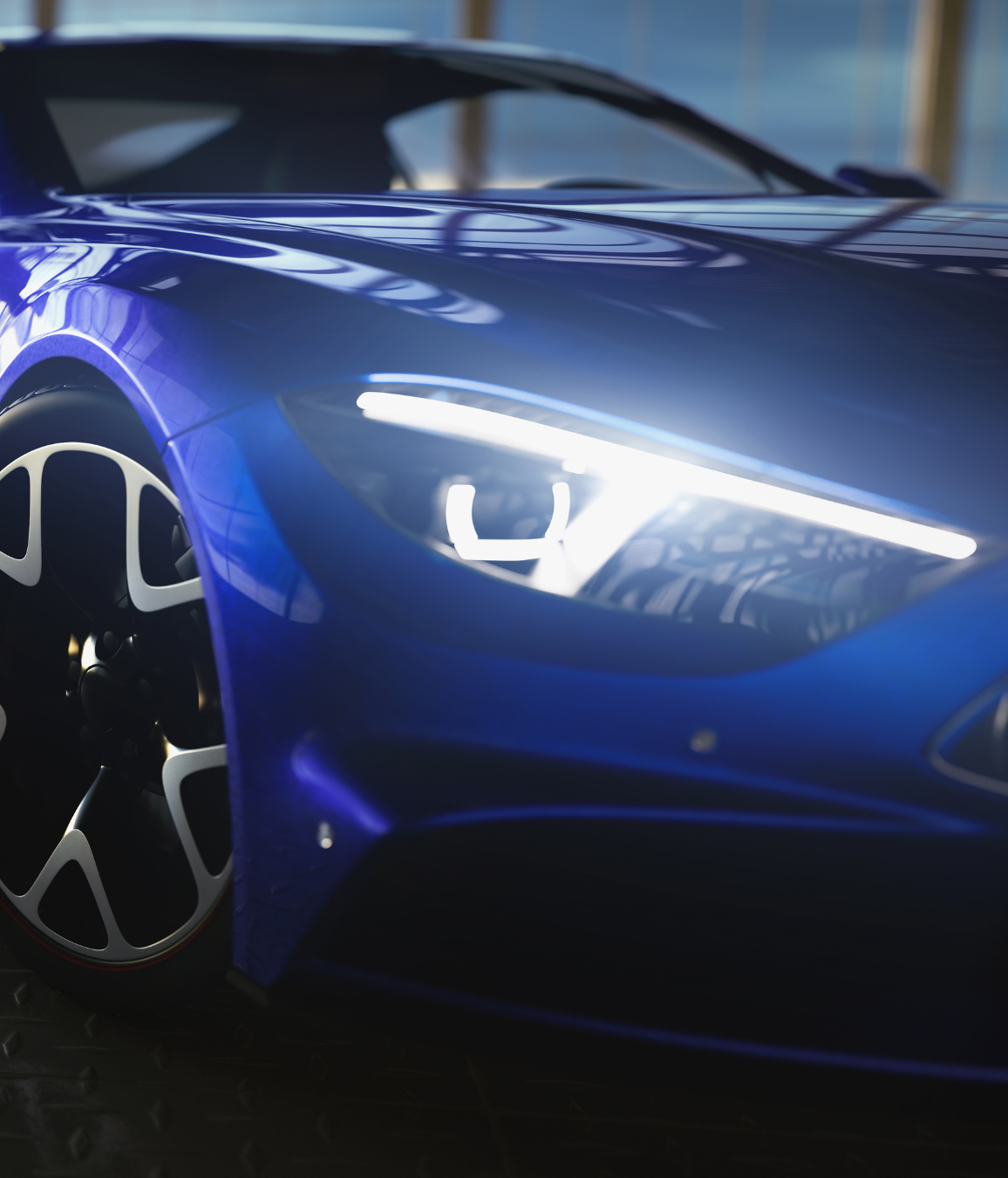 A close up of a blue car with the headlights on