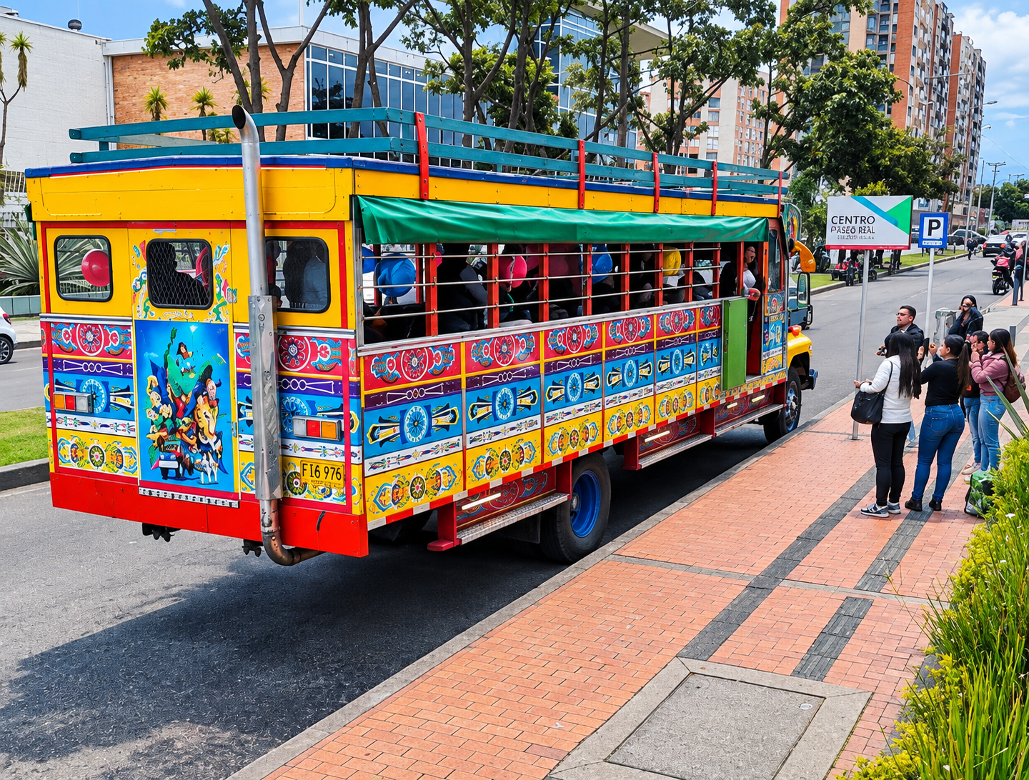 Autobús turístico descapotable y colorido en una calle soleada, junto a peatones y árboles