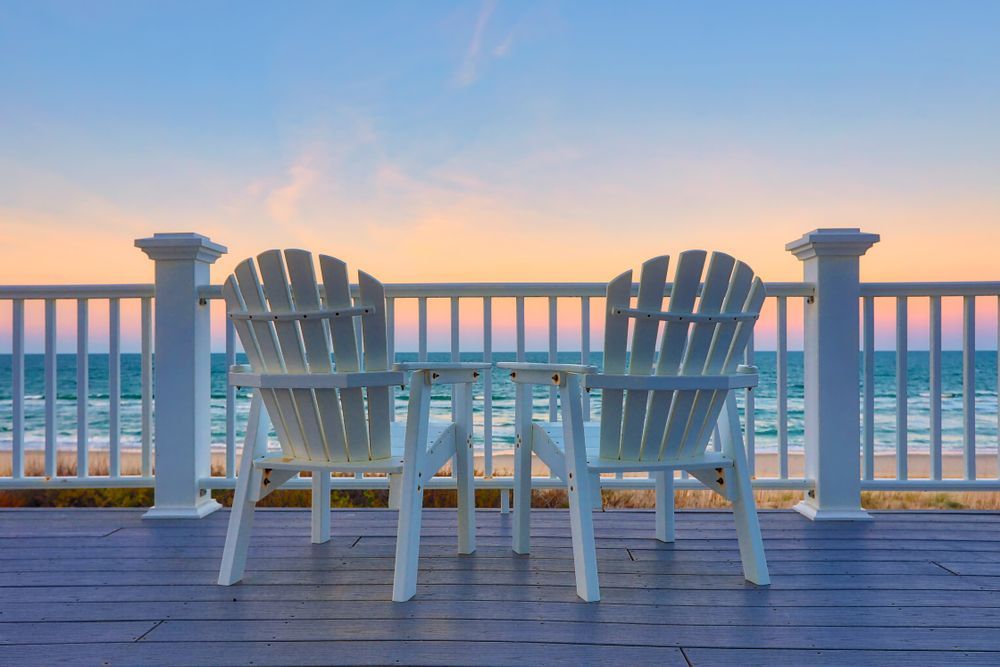 Two White Adirondack Chairs on a Deck Overlooking the Ocean at Sunset — Serene Therapy with Lana In Paddington, NSW