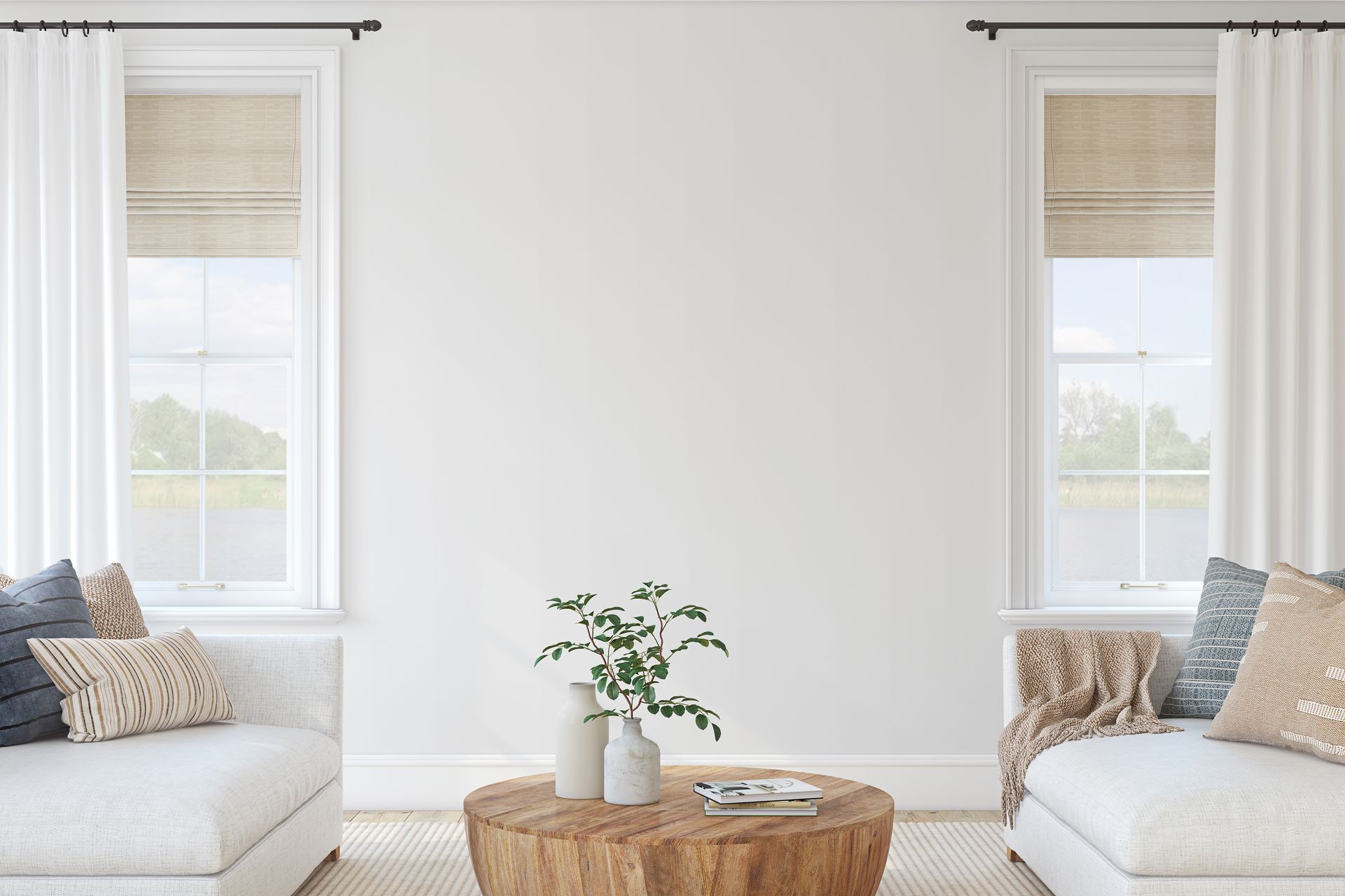 Salon avec murs blancs, deux fenêtres, deux canapés blancs et une table basse en bois.