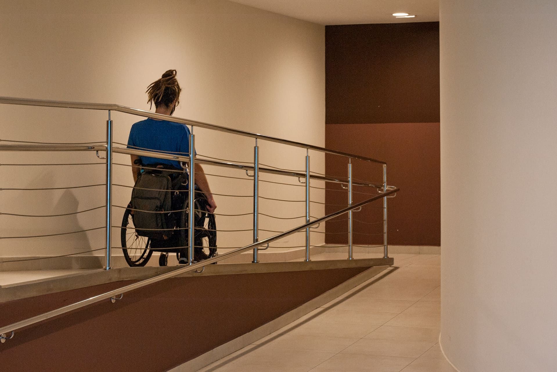 A woman in a wheelchair is sitting on a ramp.